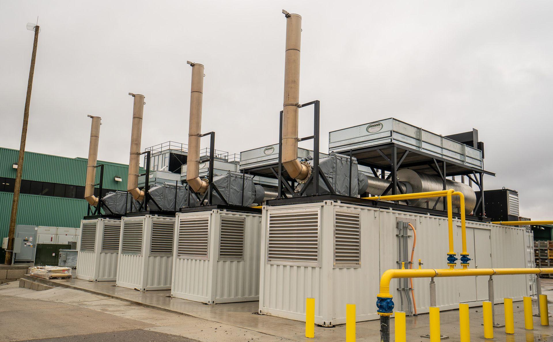 four containerized prime power generators installed on a concrete pad outside