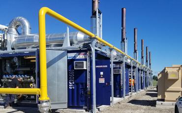 a line of containerized generators installed outside at a manufacturing plant