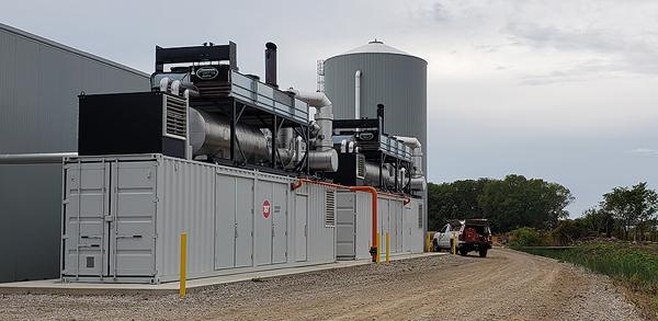 two conatainerized combined heat and power generators next to a building