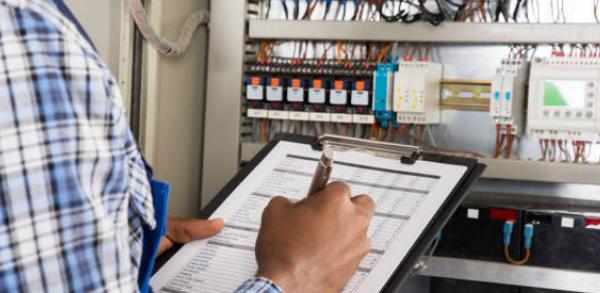 a technician completing an inspection of a control panel